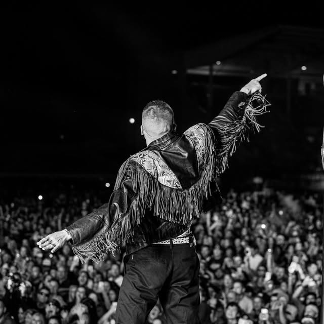 Black and white shot of a performer facing an arena crowd, Drew Pion Photography